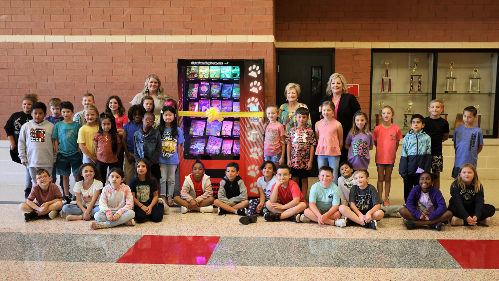 Libby Elementary students pose alongside the new book vending machine with Ms. Jamie Sanders, Mrs. Cynthia Harkrider and Mrs. Staci Davis.