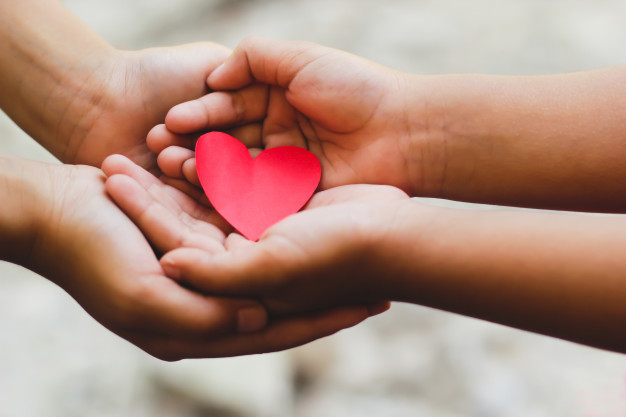 child hands holding a heart