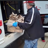 Staff Loading Buses for Food Drop Off