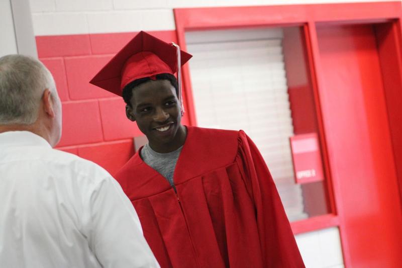 PACE graduate smiling as he enters to receive his diploma